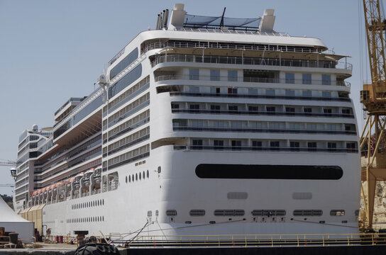Modern cruise ship cruiseship liner Divina and Magnifica being modernized over-hauled repaired refitted maintenanced by shipyard in Malta with dock and cranes