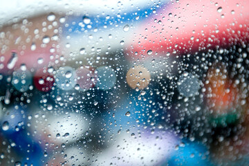 Raindrops on a car windshield during rainy weather, viewed from inside the vehicle, creating a calm and relaxing atmosphere