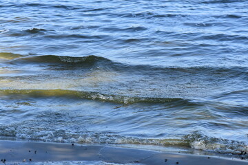 The surface of the water with waves and foam, close-up