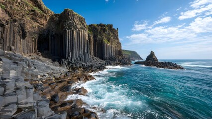 Volcanic basalt columns by the sea - hexagonal rock formations rising like organ pipes along a rugged coastline