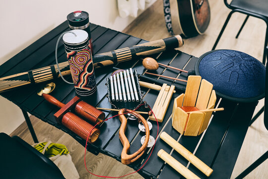 Variety of handcrafted percussion instruments displayed on a table in a music space