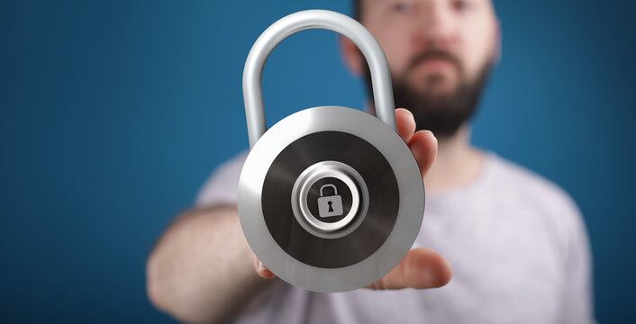 A man holds a padlock, symbolizing digital security, data privacy, and online safety. Concept of safeguarding a