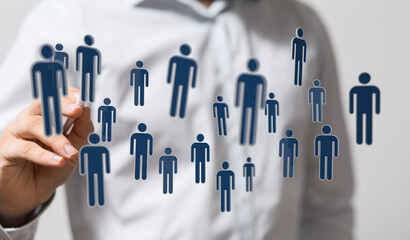 A businessperson's hand reaching towards a cluster of human figures, representing teamwork, and...