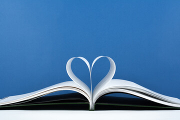 Old open hardback book, page decorate into a heart shape for love in Valentine's. love with open book heart.