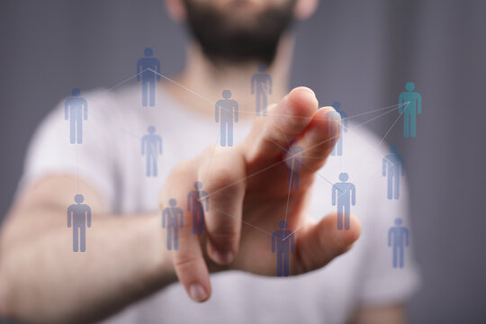 Close-up of a person's hand interacting with a network of digital people icons, symbolizing connection and glob