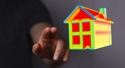 Person's hand reaching out to touch a 3D rendered house model. Illustrative of property, real...
