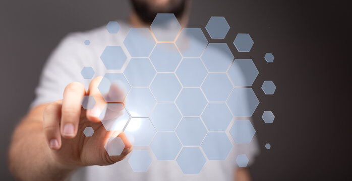 Close up shot of a man pointing at a hexagonal digital interface. Concept of technology, connection, interactio