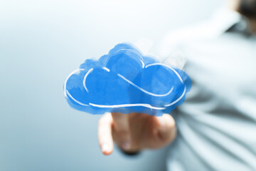 A hand interacting with a blue cloud icon representing cloud computing, digital data, storage, modern technology solutions, and online services.