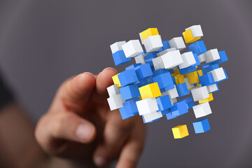 A hand holding a collection of colorful abstract cubes, symbolizing concepts like networking, data, and connect