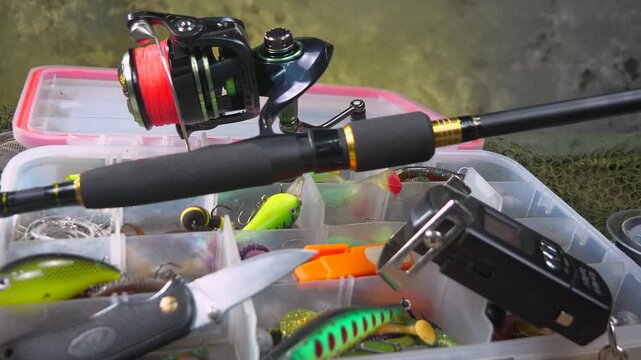 Fishing tackle is laid out on a wooden background, slowly moving along a horizontal plane. Fishing tackle for fun.