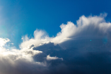 Obraz premium Dramatic cumulonimbus storm clouds dominate a vivid blue sky. Powerful and dynamic weather showcasing nature's force and beauty