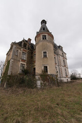 Derelict chateau with tower and overgrown grounds - abandoned historic mansion in rural decay