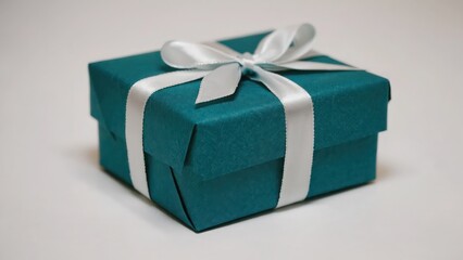  Small festive present with green wrapping and silver bow, on white background,
