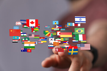 Human hand touching international flags representing global cooperation, travel, and...