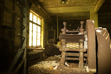Rusted machinery in abandoned chocolate factory with sunlit industrial window