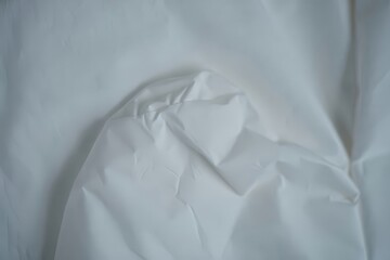 Close-up of crumpled white disposable protective suit material.