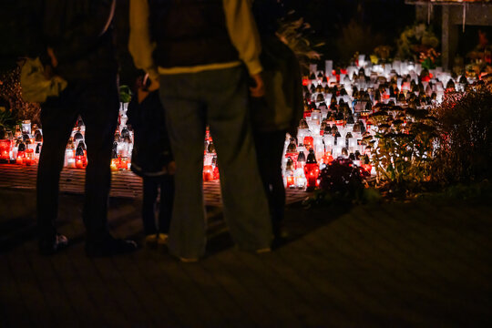 Woman Standing Before Hundreds of Glowing Memorial Candles During a Nighttime Remembrance