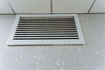 ceiling grille inspection, overhead vent in tiled office, metal vent grille under cool fluorescent office lighting, detailed view of ceiling vent with textured acoustic tiles in office environment