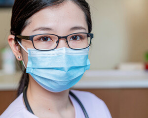 Girl health worker wearing glasses and a protective face mask