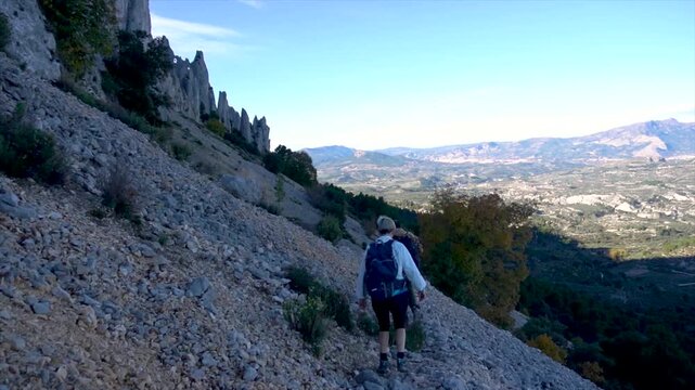 Slow motion, a copule walking on a rocky path in Serrella mountain, Alicante (Spain).
