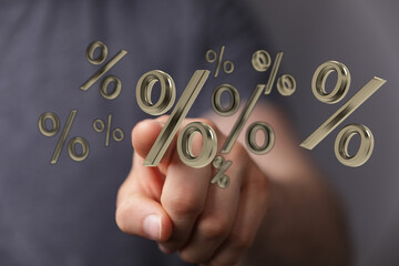 Digitally rendered percentage symbols appear to be touching by a hand. Represents concepts of...