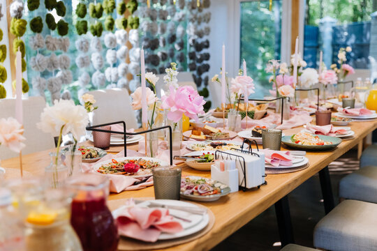 Elegant banquet table with pink flowers and candles, wedding reception decor in soft pastels