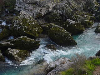 A turquoise mountain river rushes through mossy rocks, creating a hidden waterfall oasis in the heart of Montenegro.