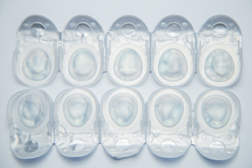 Close-up top view of daily disposable contact lenses in disposable protective case on a white background. The concept of ophthalmology, vision correction, eye care. High quality photo