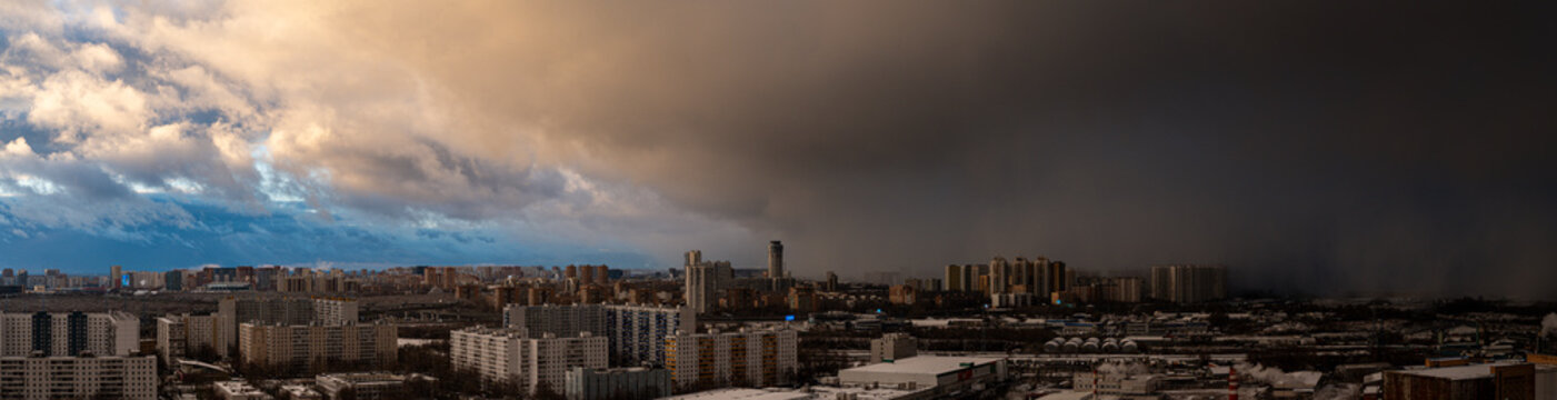 Moscow, Russia - October 15, 2025: Panorama of a big city from a height a snowstorm is approaching the blue sky. A cyclone is coming to the city, aerial photography. Snow forecast. High quality photo
