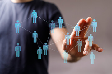 Hand touching digital network of people, representing connection, communication, social media, and teamwork. Co