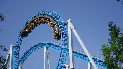 Amusement trolley motion blur speed effect makes circle loop turns upside down, roller coaster. Frightened of people repenting on carts