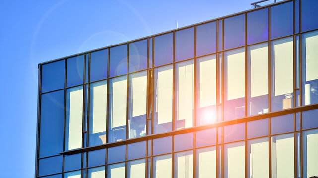 Office building in loft style. Facade of commercial office with windows. Glasses walls of an industrial building.