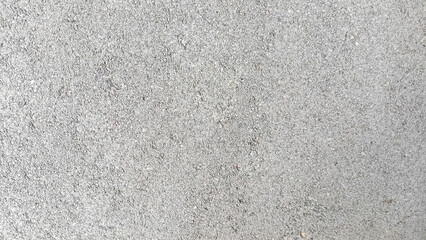 Rough and sandy surface texture in light gray color, suitable for a minimalist abstract background.
