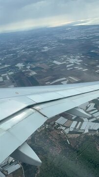 Sky farm vista, Fields and greenhouses from above, Aircraft view of cultivated lands and glasshouses, Overhead scene showcasing agricultural plots and greenhouse facilities captured during flight