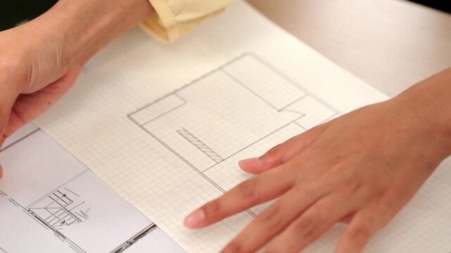 Video of clever architect or smart engineer using measurement tool and pencil hand writing a detail on blueprint for construction accuracy at architectural office. Focus on hand. Closeup. Delineation.