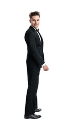 happy young businessman in black tuxedo smiling and standing