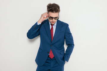 Businessman adjusting sunglasses and looking down