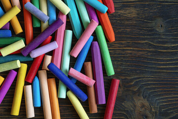 Different colorful oil pastel crayons on dark rustic table. Flat lay, copy space