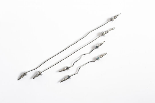 A set of stainless steel capillaries and tubing with fittings, used for connecting components in an HPLC liquid chromatography system. Scientific equipment for a lab on white background.