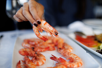 Hand holding sanlúcar langostino prawn by plate