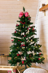 Christmas tree decorated with bow and red toys