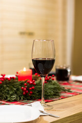 A glass of wine on a table in a Christmas interior. Festive atmosphere