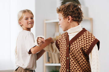 Authentic portrayal of a playful school lifestyle moment, capturing two children in a warm, friendly exchange that reflects everyday learning and lighthearted authentic interaction.