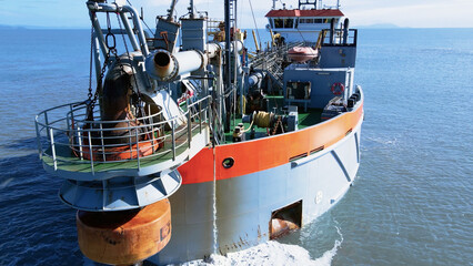 Aerial scene suction dredger ship sailing at sea, showing equipment and machinery used in large-scale dredging operations.
