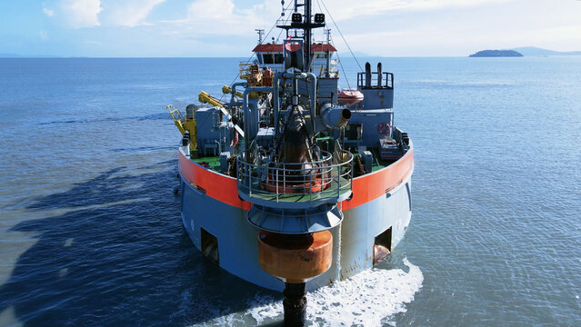 Aerial scene suction dredger ship sailing at sea, showing equipment and machinery used in large-scale dredging operations.
