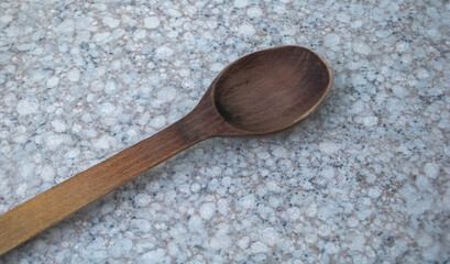 Wooden kitchen spoon on stone countertop
