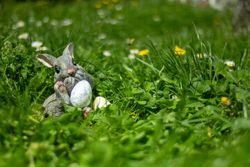 Easter bunny holding easter eggs. sitting in grass. Easter photo