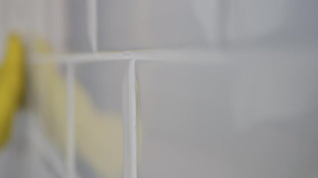 Man Wearing Gloves in Hands Cleans Bathroom Faience. Household Chores, Cleaning and Sanitizing the Faience in the Kitchen. 