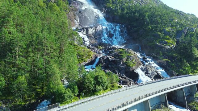 Drone flying over Langfoss in Fj&aelig;ra, capturing the powerful waterfall water rushing down the mountainside in dramatic Norwegian scenery.
