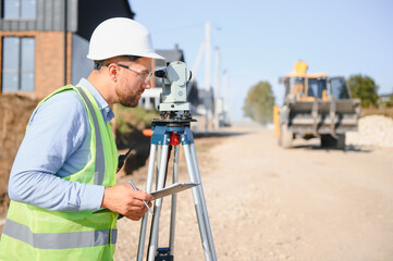 Male surveyor using theodolite for land measurement